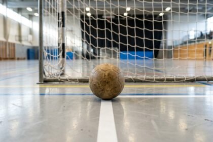 Handball liegt auf dem Hallenboden vor dem Tor