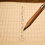 Zahlen und ein Stift auf kariertem Papier
