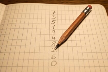 Zahlen und ein Stift auf kariertem Papier