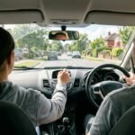 Wie lange dauert ein Führerschein: Fahrschulauto mit Fahrlehrer bei einer Fahrstunde