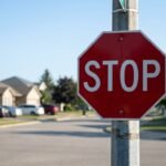 Wie viele Ecken hat ein Stoppschild: rotes achteckiges Stoppschild an einer Kreuzung