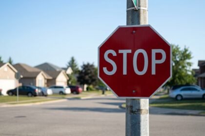 Wie viele Ecken hat ein Stoppschild: rotes achteckiges Stoppschild an einer Kreuzung