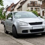 Pkw mit automatischer Kraftübertragung am Gefälle geparkt, Räder zum Bordstein eingeschlagen