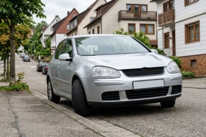 Pkw mit automatischer Kraftübertragung am Gefälle geparkt, Räder zum Bordstein eingeschlagen